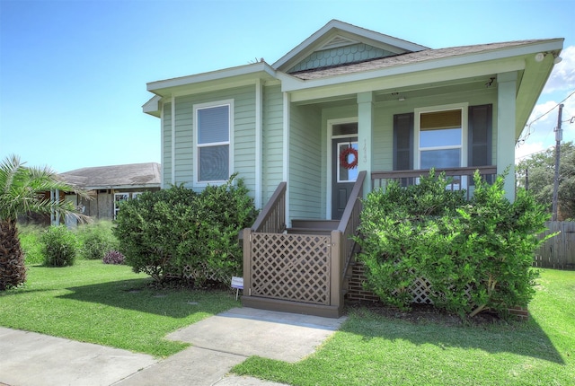 view of front of home with covered porch and a front lawn