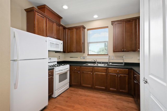 kitchen featuring sink, white appliances, and light hardwood / wood-style floors