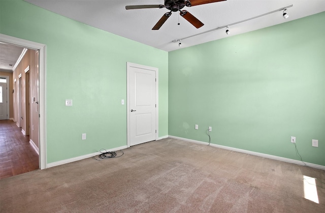 empty room with ceiling fan, carpet, and track lighting