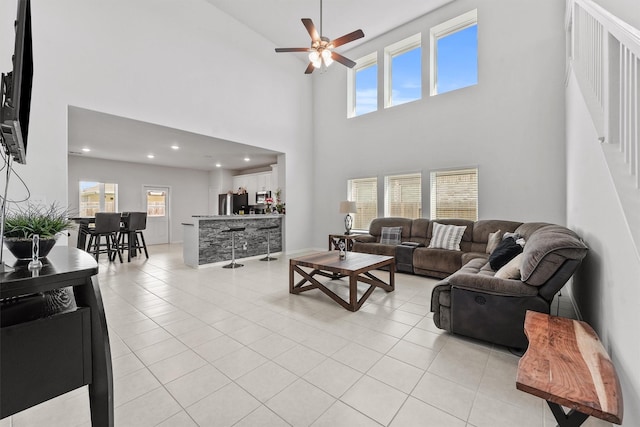 tiled living room with a towering ceiling and ceiling fan