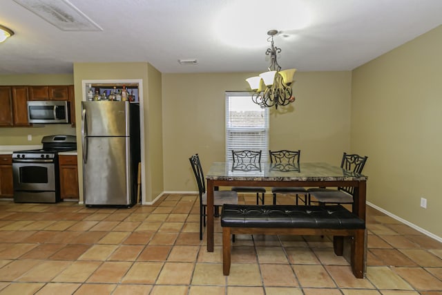 tiled dining space with a chandelier