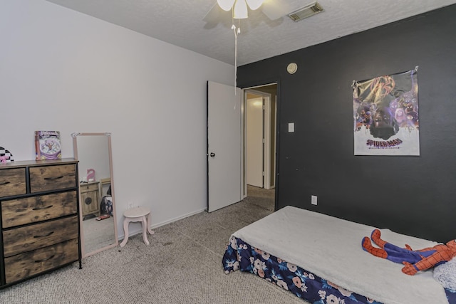 carpeted bedroom with a textured ceiling and ceiling fan