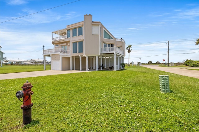 exterior space featuring a balcony, a garage, and a lawn