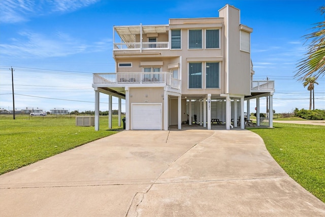 raised beach house with a garage, a front lawn, and a carport