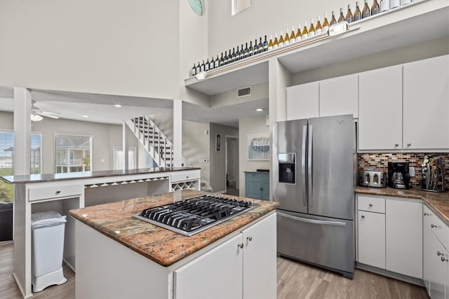 kitchen featuring white cabinets, stainless steel appliances, a kitchen island, and ceiling fan