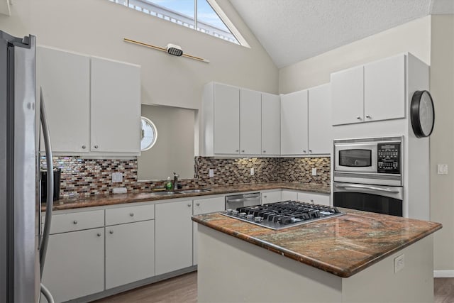 kitchen with white cabinetry, stainless steel appliances, and a kitchen island