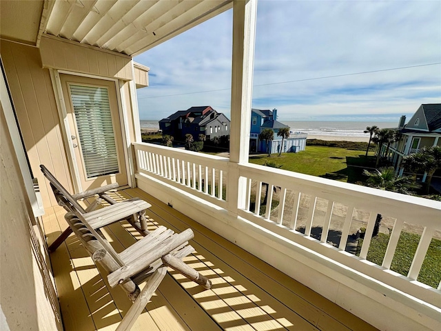 balcony with a water view and a view of the beach