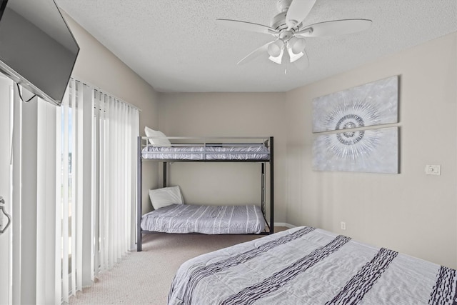 carpeted bedroom with ceiling fan and a textured ceiling