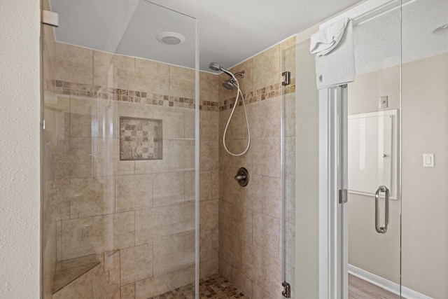 bathroom featuring hardwood / wood-style flooring and walk in shower