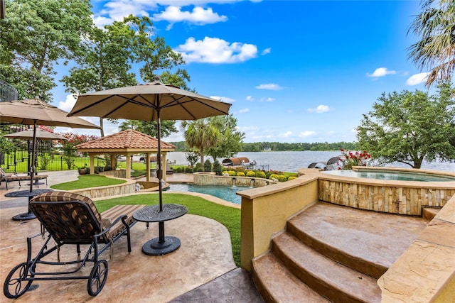 view of patio / terrace with a pool with hot tub, a gazebo, and a water view