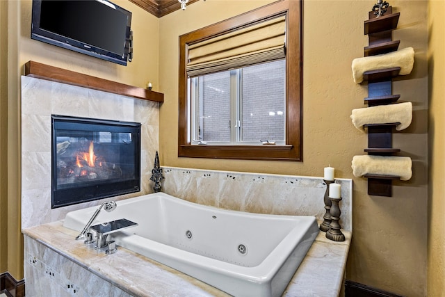 bathroom featuring tiled bath, crown molding, and a fireplace