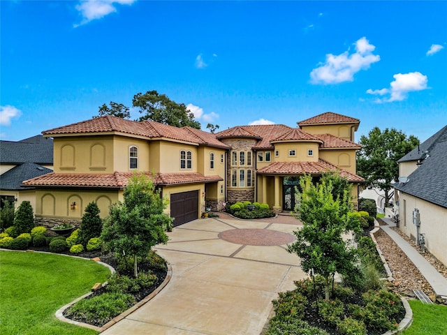 mediterranean / spanish-style home with a garage and a front lawn