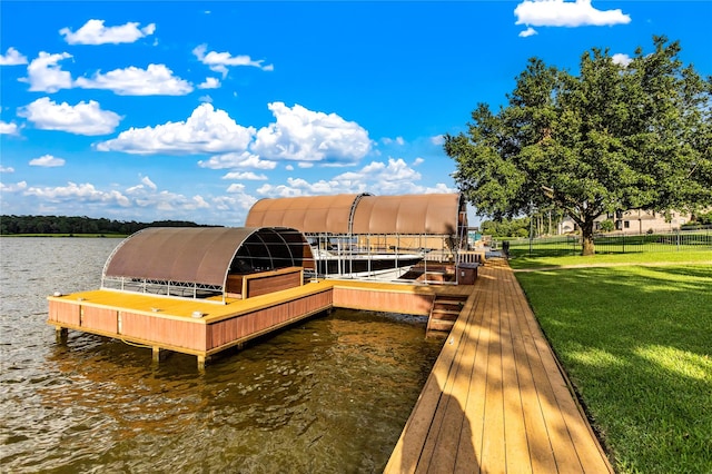 view of dock with a lawn and a water view