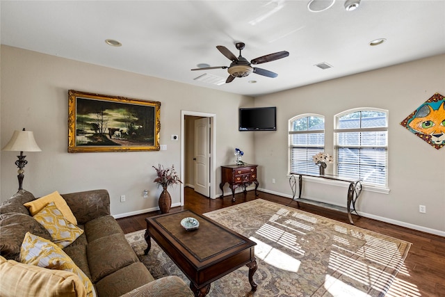 living room featuring dark wood-type flooring and ceiling fan