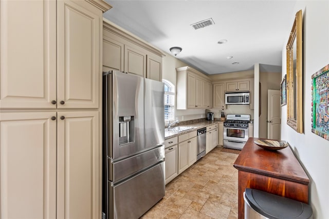 kitchen with sink, appliances with stainless steel finishes, and cream cabinetry