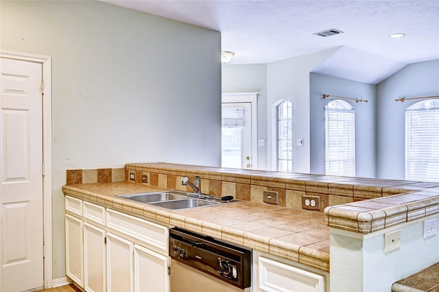 kitchen featuring sink, white cabinets, dishwashing machine, kitchen peninsula, and tile countertops