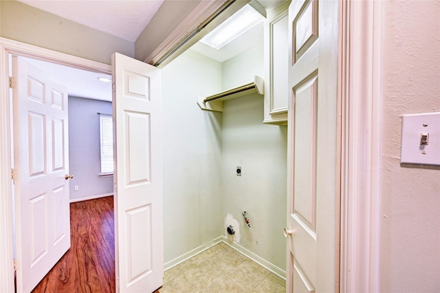 clothes washing area with hookup for an electric dryer and light wood-type flooring