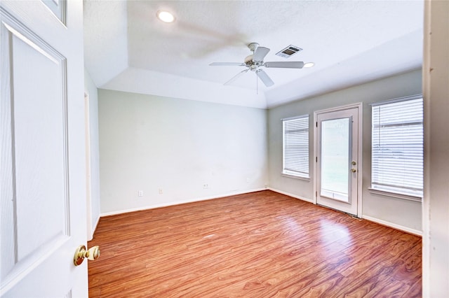 spare room featuring ceiling fan, light hardwood / wood-style floors, a textured ceiling, and plenty of natural light