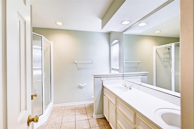 bathroom featuring tile patterned floors, toilet, walk in shower, and vanity