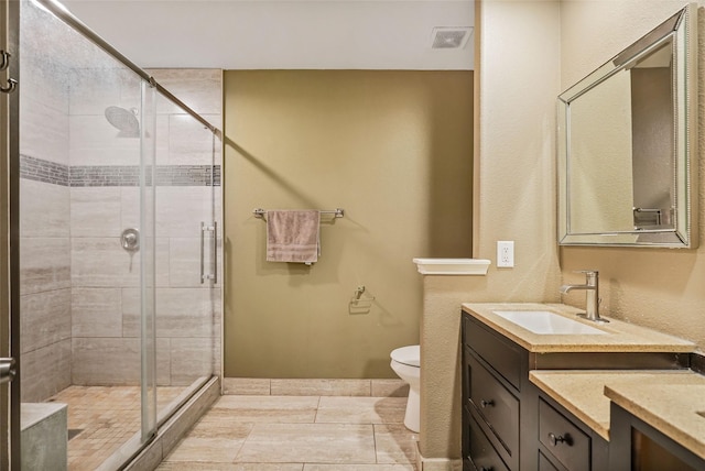 bathroom with toilet, a shower with shower door, and vanity