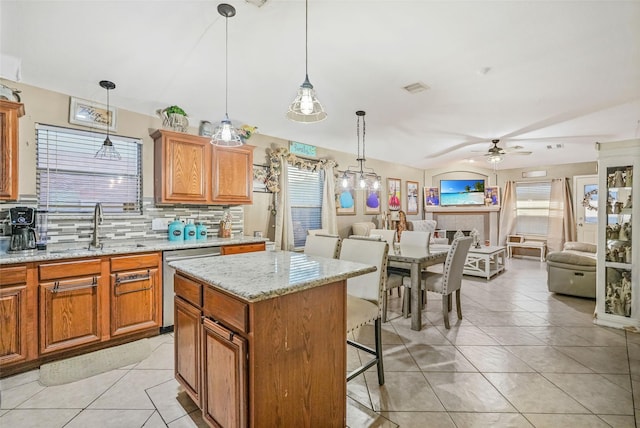 kitchen featuring a kitchen island, stainless steel dishwasher, tasteful backsplash, and pendant lighting