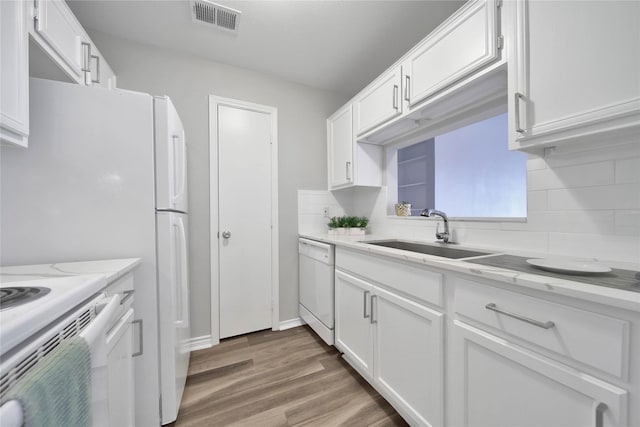 kitchen featuring dishwasher, sink, white cabinets, light stone countertops, and hardwood / wood-style floors