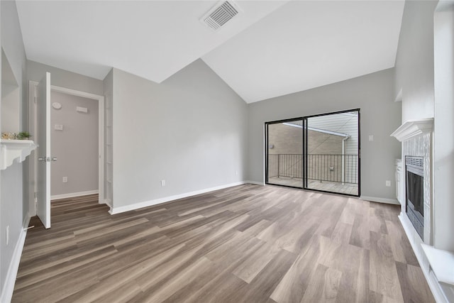 unfurnished living room with hardwood / wood-style floors and lofted ceiling