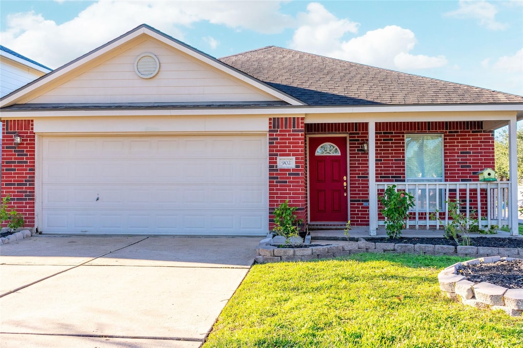 view of front of property with a garage, a front yard, and covered porch