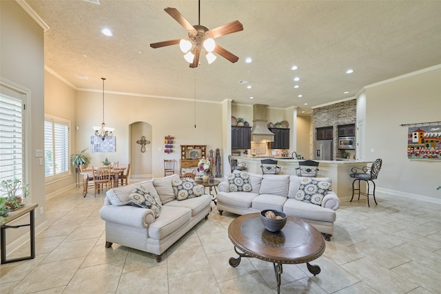 tiled living room with crown molding, ceiling fan with notable chandelier, and a textured ceiling