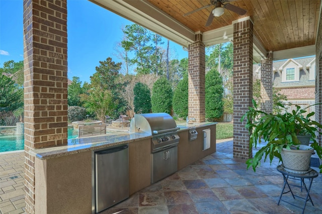 view of patio with area for grilling, a grill, and ceiling fan