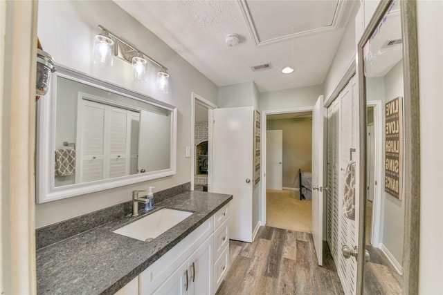 bathroom featuring wood-type flooring, vanity, and a textured ceiling