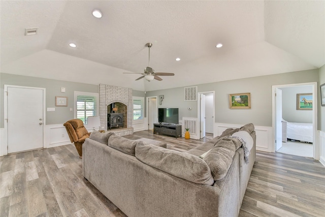 living room featuring a raised ceiling, a textured ceiling, and light hardwood / wood-style flooring