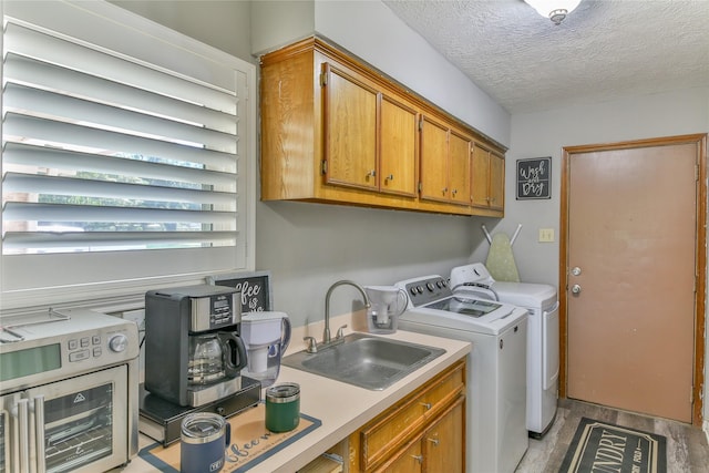 washroom with wine cooler, sink, cabinets, separate washer and dryer, and a textured ceiling