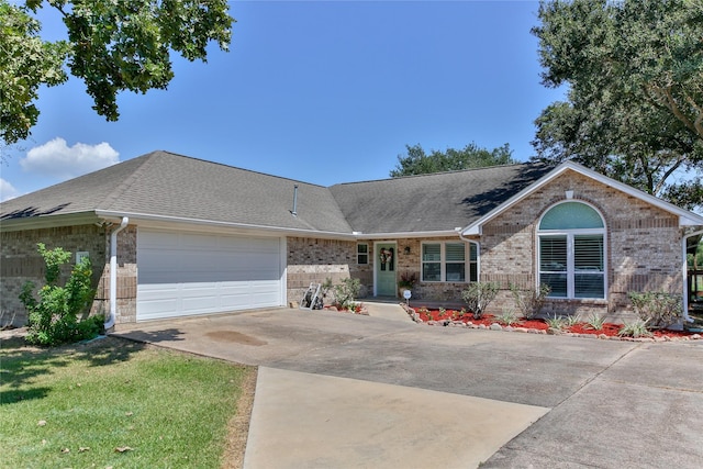 ranch-style home with roof with shingles, driveway, brick siding, and an attached garage