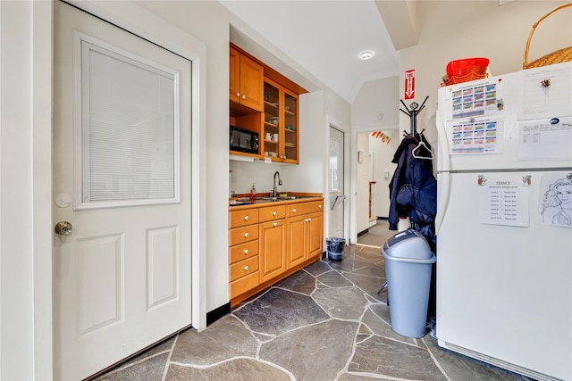 kitchen featuring sink, black microwave, and white refrigerator