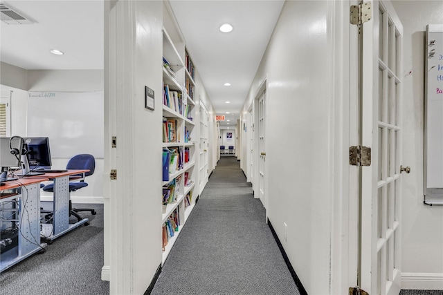 hall featuring dark carpet