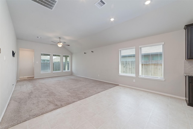 unfurnished living room featuring ceiling fan, light colored carpet, and vaulted ceiling