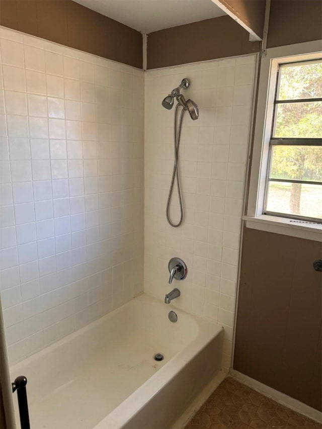 bathroom featuring tiled shower / bath combo and tile patterned flooring