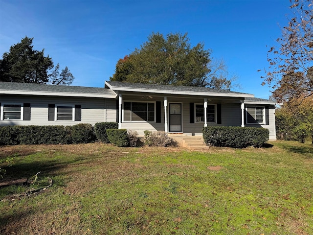 ranch-style house featuring covered porch and a front yard