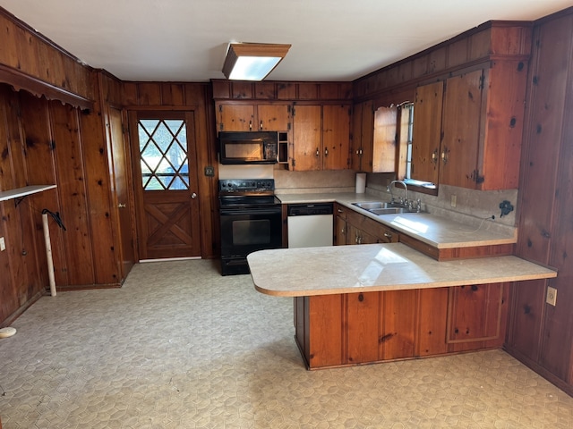 kitchen with kitchen peninsula, black appliances, sink, and a wealth of natural light