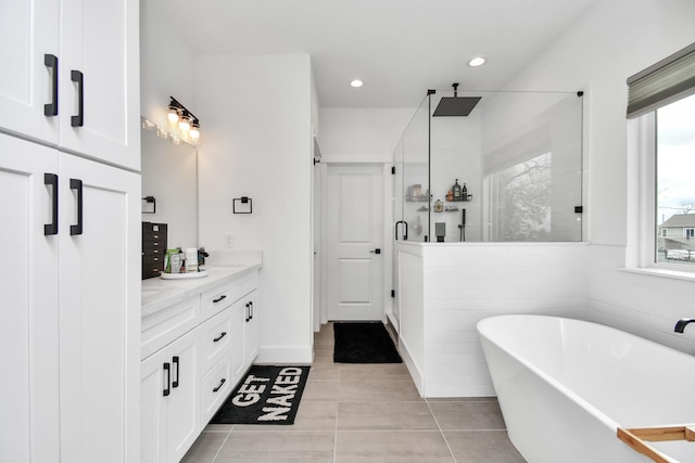 bathroom featuring tile patterned flooring, vanity, and shower with separate bathtub