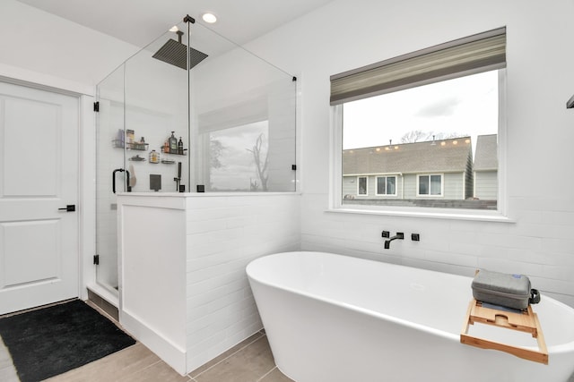 bathroom featuring shower with separate bathtub and tile patterned flooring