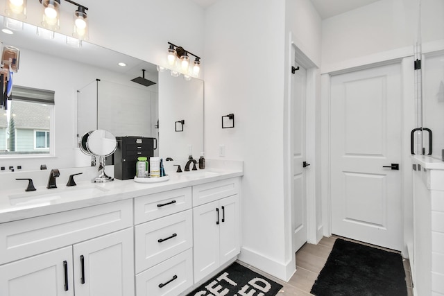 bathroom featuring a shower with shower door, hardwood / wood-style floors, and vanity