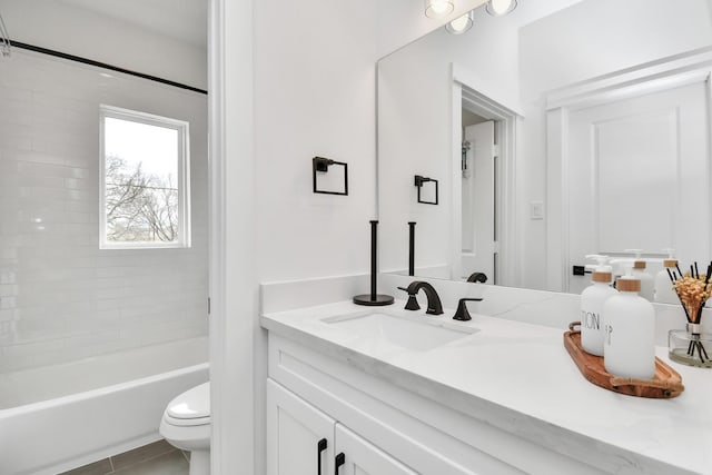 full bathroom with toilet, tiled shower / bath, tile patterned floors, and vanity