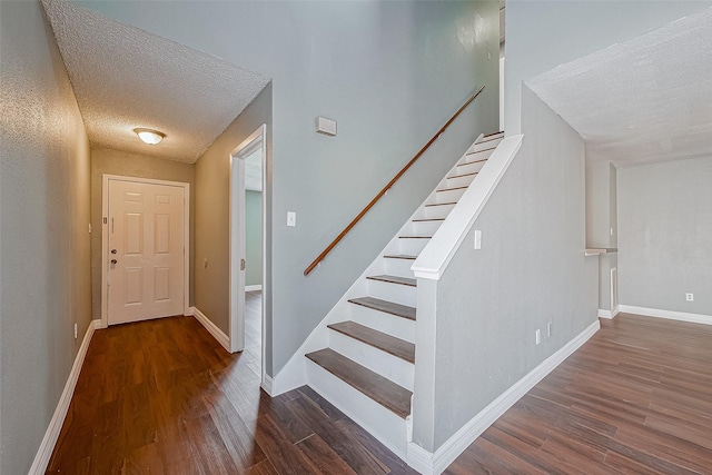 stairs featuring hardwood / wood-style flooring and a textured ceiling