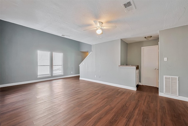 empty room featuring ceiling fan, dark wood-type flooring, and a textured ceiling