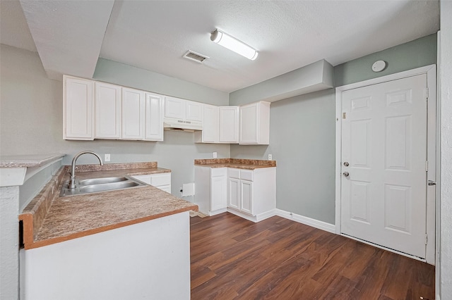 kitchen featuring sink, white cabinetry, dark wood-type flooring, and a textured ceiling