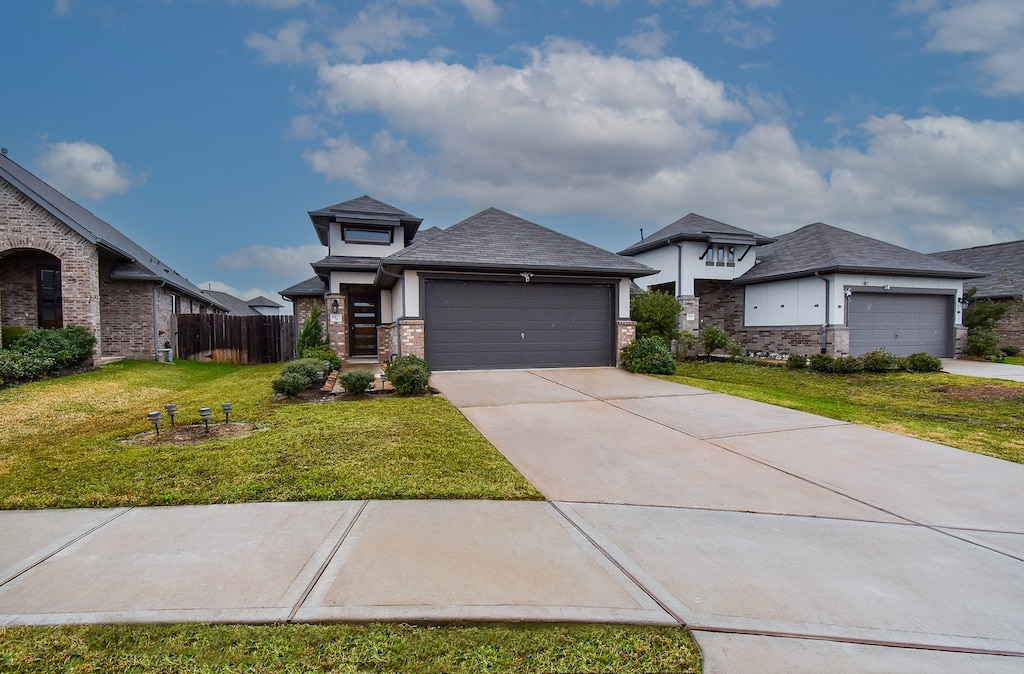 prairie-style house featuring a garage and a front yard