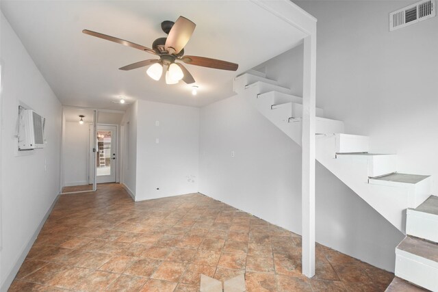 spare room featuring a wall mounted AC and ceiling fan