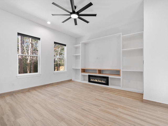 unfurnished living room with light hardwood / wood-style flooring and ceiling fan